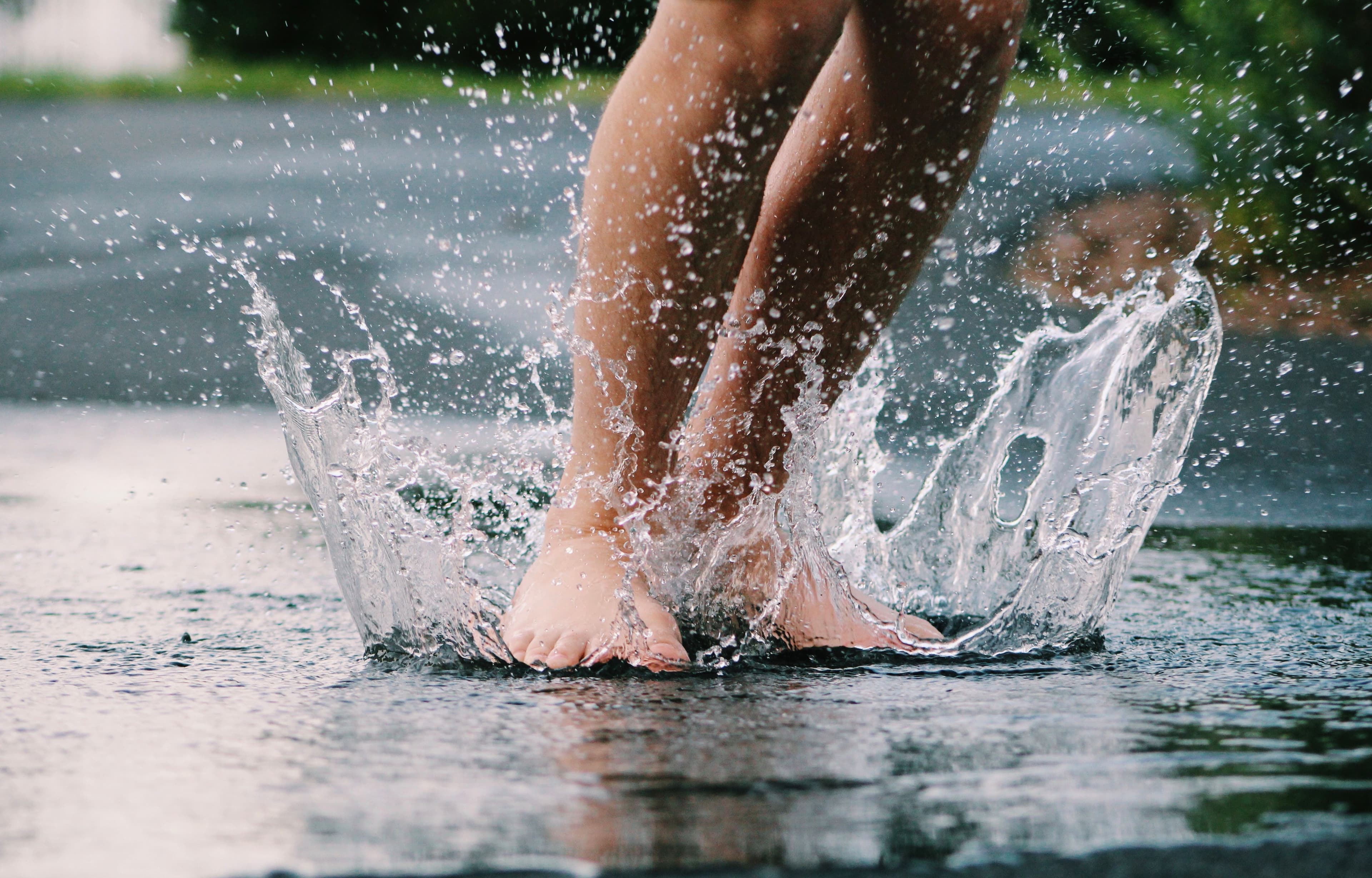 kid's feet splashing in a puddle at a splash pad
