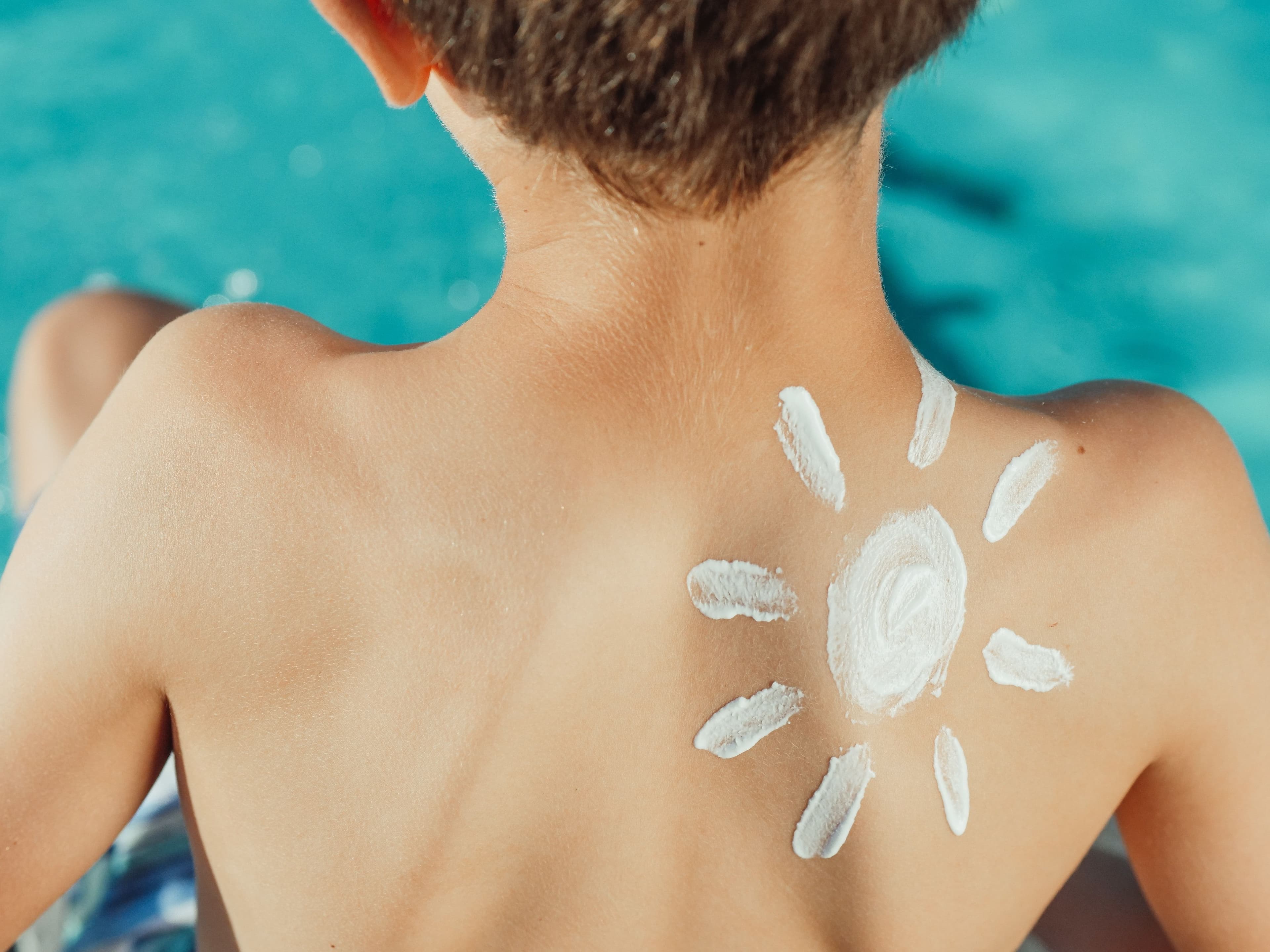 a young boy wearing sunscreen