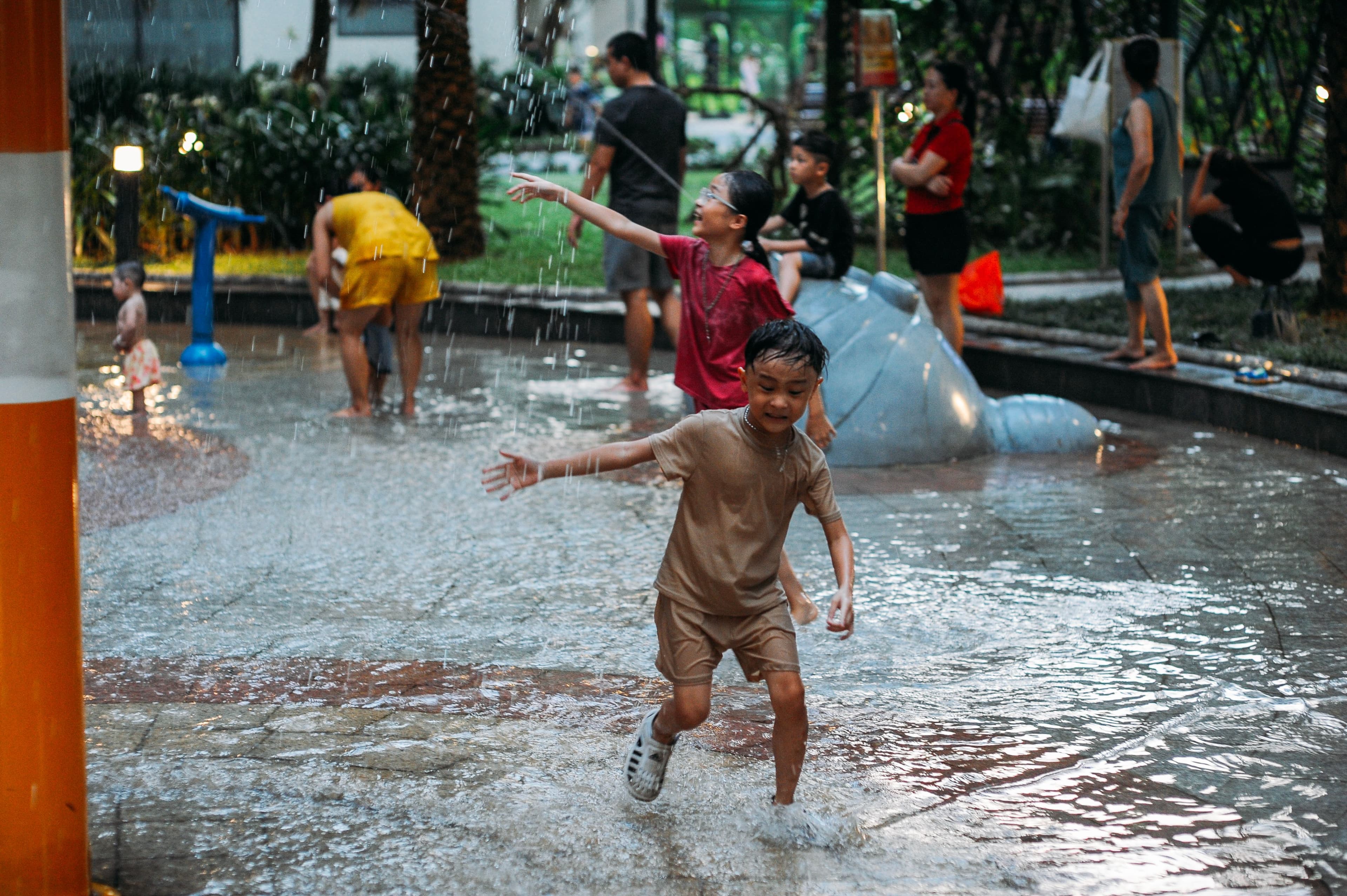 a group of young children playing in a splash pad